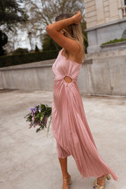 Robe plissée à ouverture latérale portée par une femme, vue de trois-quarts, bras levé, bouquet