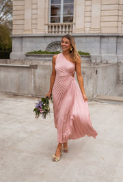 Robe plissée à ouverture latérale portée par une femme, vue de face, bouquet, façade