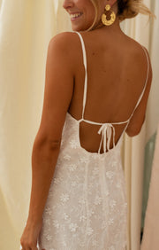 Robe courte brodée dos nu portée par une femme, vue rapprochée, dos nu, lacets croisés