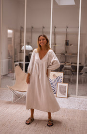 Robe longue à manches ballon portée par une femme, vue de face, bureau, sandales