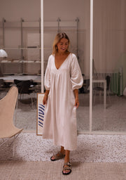 Robe longue à manches ballon portée par une femme, vue de face, cadre rayé, manches ballon