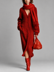 Robe midi rouge en maille portée avec une écharpe à franges, vue de face sur fond gris.