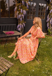 Robe lurex à manches courtes portée par une femme, assise, chaise en bois, pelouse