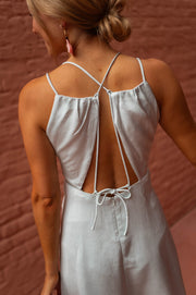 Robe satinée cache-cœur courte portée par une femme, vue rapprochée, lacets dans le dos, bretelles