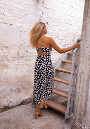 Robe mi-longue fleurie fendue portée par une femme, vue de dos, escalier, nœud dans le dos
