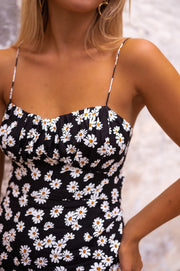 Robe mi-longue fleurie fendue portée par une femme, vue rapprochée, décolleté, bretelles fines