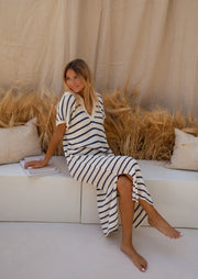 Robe longue rayée effet maille portée par une femme, assise, canapé, jambes croisées