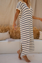 Robe longue rayée effet maille portée par une femme, vue de profil, canapé, rayures