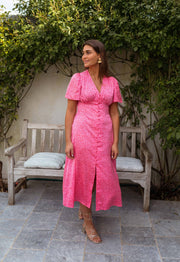 Robe boutonnée à col V portée par une femme, vue de face, mur de lierre, banc