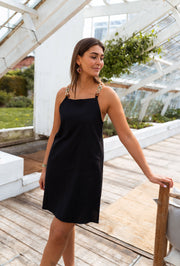 Robe à bretelles bijou portée par une femme, vue de trois-quarts, rambarde, serre