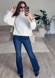 Pull col roulé beige — vue portée en pied, lunettes de soleil, intérieur lumineux