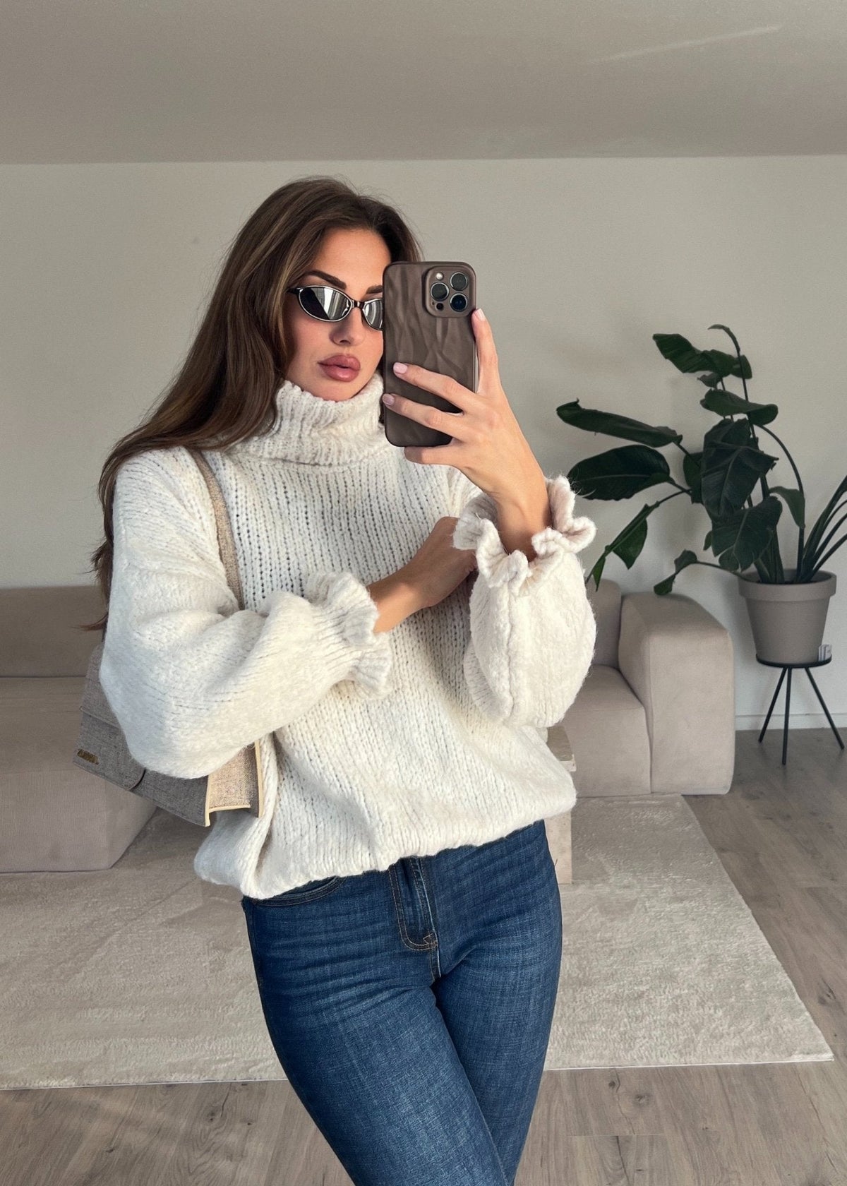 Pull col roulé beige — selfie au miroir, vue portée de face, jean évasé bleu