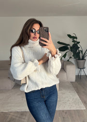Pull col roulé beige — selfie au miroir, vue portée de face, jean évasé bleu