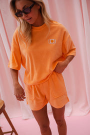 Short éponge à cordon porté par une femme, vue rapprochée, t-shirt orange, lunettes