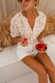 Short doublé effet tweed porté par une femme, assise, fraises