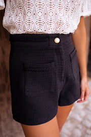 Short court effet tweed porté par une femme, vue rapprochée, poches, bouton doré