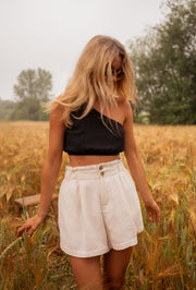Short en coton légèrement évasé porté par une femme, vue de face, top noir, champ de blé