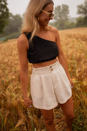 Short en coton légèrement évasé porté par une femme, vue de trois-quarts, top noir, cheveux longs