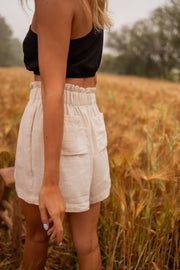 Short en coton légèrement évasé porté par une femme, vue rapprochée, short beige, blé