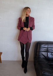 Jupe-short à carreaux drapée porté par une femme, silhouette entière, blazer bordeaux, collants