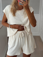 Short éponge à poches porté par une femme, vue rapprochée, ensemble crème, téléphone