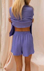 Short court fluide porté par une femme, vue de dos, chemise relevée