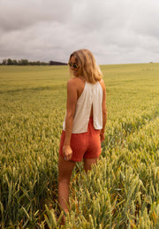 Short court à taille élastique porté par une femme, vue de dos, champ de blé