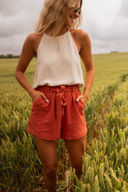 Short court à taille élastique porté par une femme, vue de face, blé, top crème