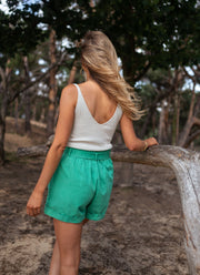 Top à fines bretelles porté par une femme, vue de dos, short vert, forêt