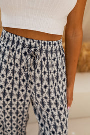 Pantalon fluide à motif tie-dye porté par une femme, vue rapprochée, taille élastique, top blanc