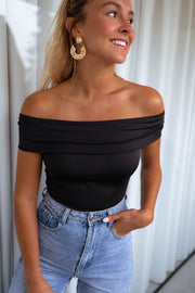 Body bustier à épaules dégagées porté par une femme, vue rapprochée, col bardot, boucles d'oreilles