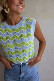Top crochet ajouré col rond porté par une femme, vue rapprochée, sourire, boucles d'oreilles