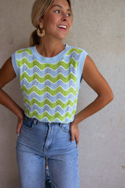 Top crochet ajouré col rond porté par une femme, vue rapprochée, mains sur les hanches