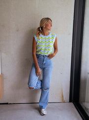 Top crochet ajouré col rond porté par une femme, silhouette entière, fenêtre, jean