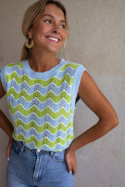 Top crochet ajouré col rond porté par une femme, vue rapprochée, sourire, jean