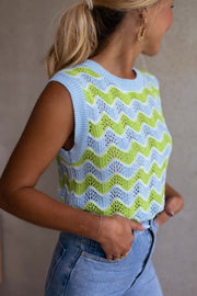 Top crochet ajouré col rond porté par une femme, vue rapprochée, profil, mains dans les poches