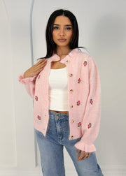 Cardigan maille motif floral rose — vue portée de trois-quarts, cadrée à la taille, manche et motif