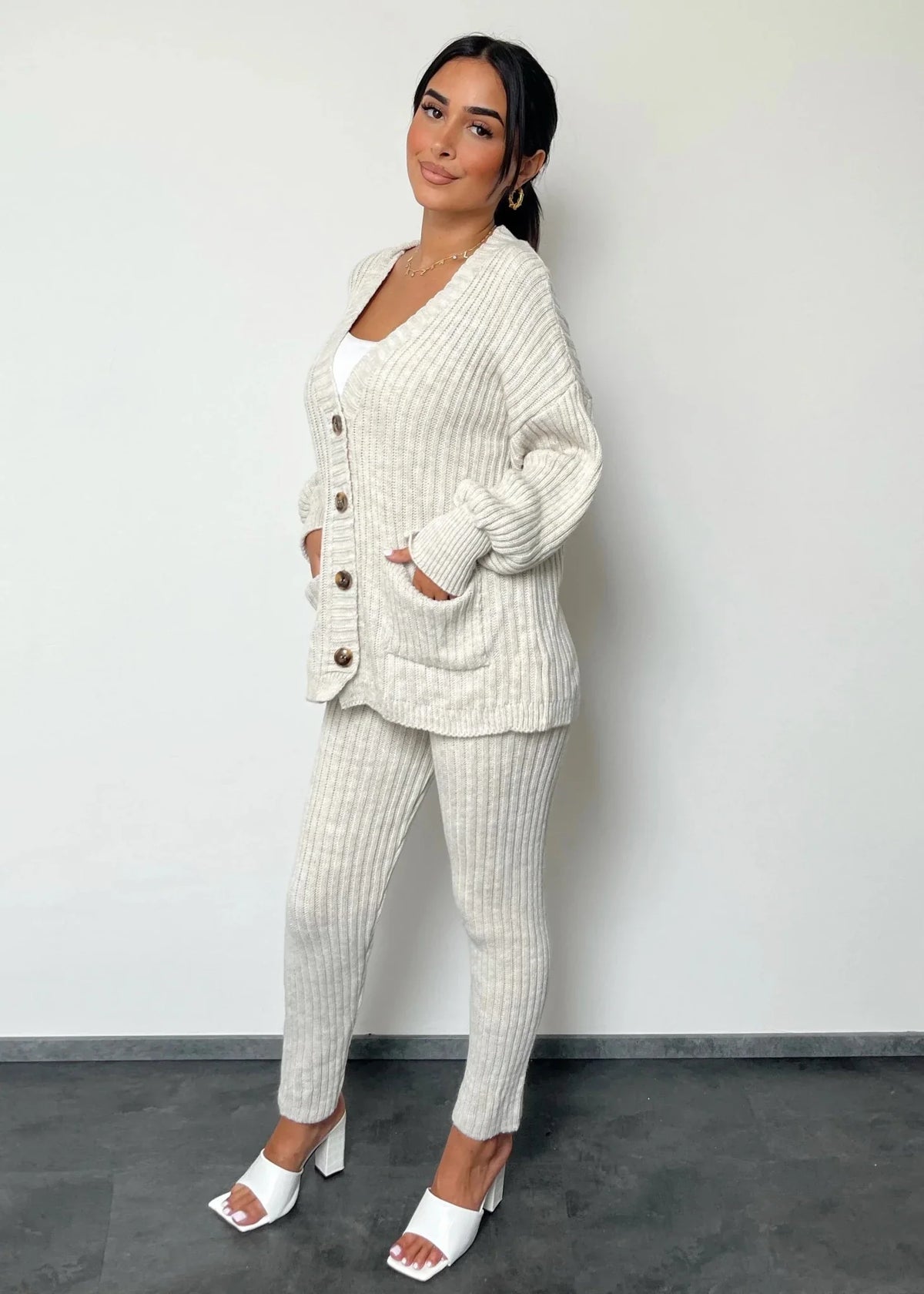 Ensemble maille cardigan et pantalon — vue portée en pied, mains dans les poches du cardigan, baskets blanches