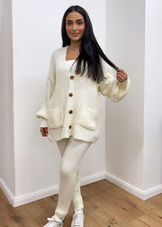 Ensemble maille cardigan et pantalon — vue portée en pied, sourire, main dans les cheveux