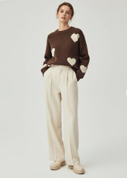 Pull à motif cœurs — vue portée en pied, cœurs blancs, pantalon large crème
