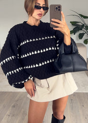 Pull noir à motif structuré — selfie au miroir, plan moyen sur le volume des manches