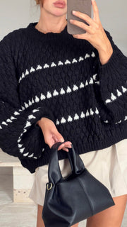 Pull noir à motif structuré — selfie au miroir, gros plan du buste, petit sac noir