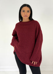 Pull ample rouge foncé — vue portée de face, col rond haut, legging noir et bottes épaisses
