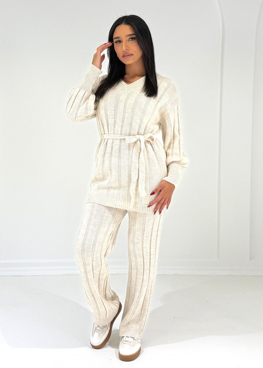 Ensemble maille beige col V — vue portée en pied, haut ceinturé et pantalon large, baskets blanches