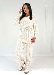 Ensemble maille beige col V — vue portée en pied, haut ceinturé et pantalon large, baskets blanches