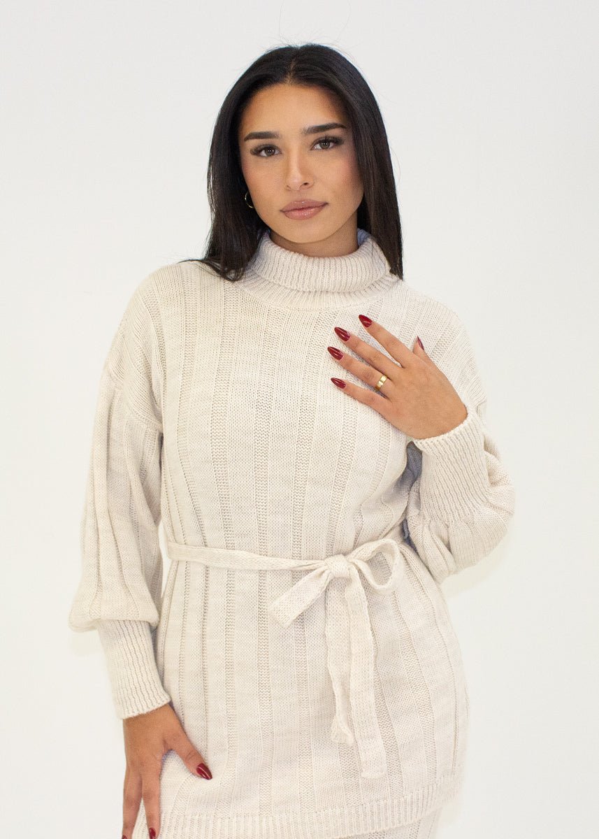 Ensemble maille beige col roulé — vue rapprochée de face, maille torsadée, ceinture nouée à la taille