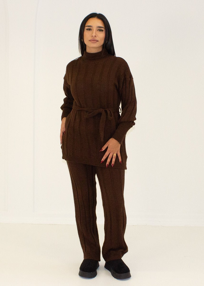 Ensemble brun foncé col roulé — vue portée en pied, tunique ceinturée et pantalon droit, bottes noires épaisses