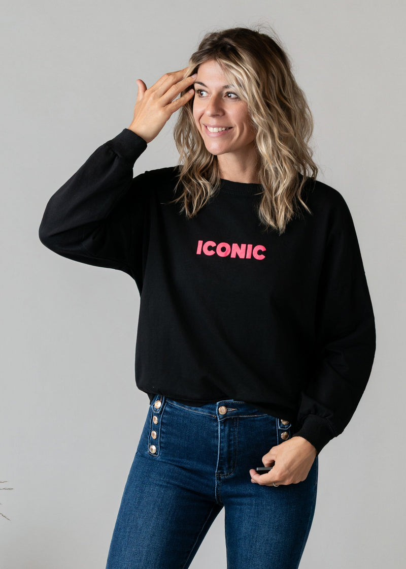 Sweat fin en molleton porté par une femme, vue de trois-quarts, main sur le front, jean