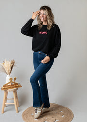 Sweat fin en molleton porté par une femme, silhouette entière, tabouret, main sur la tête