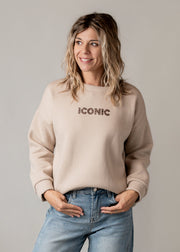 Sweat molletonné imprimé au dos porté par une femme, vue rapprochée, mains dans les poches, jean